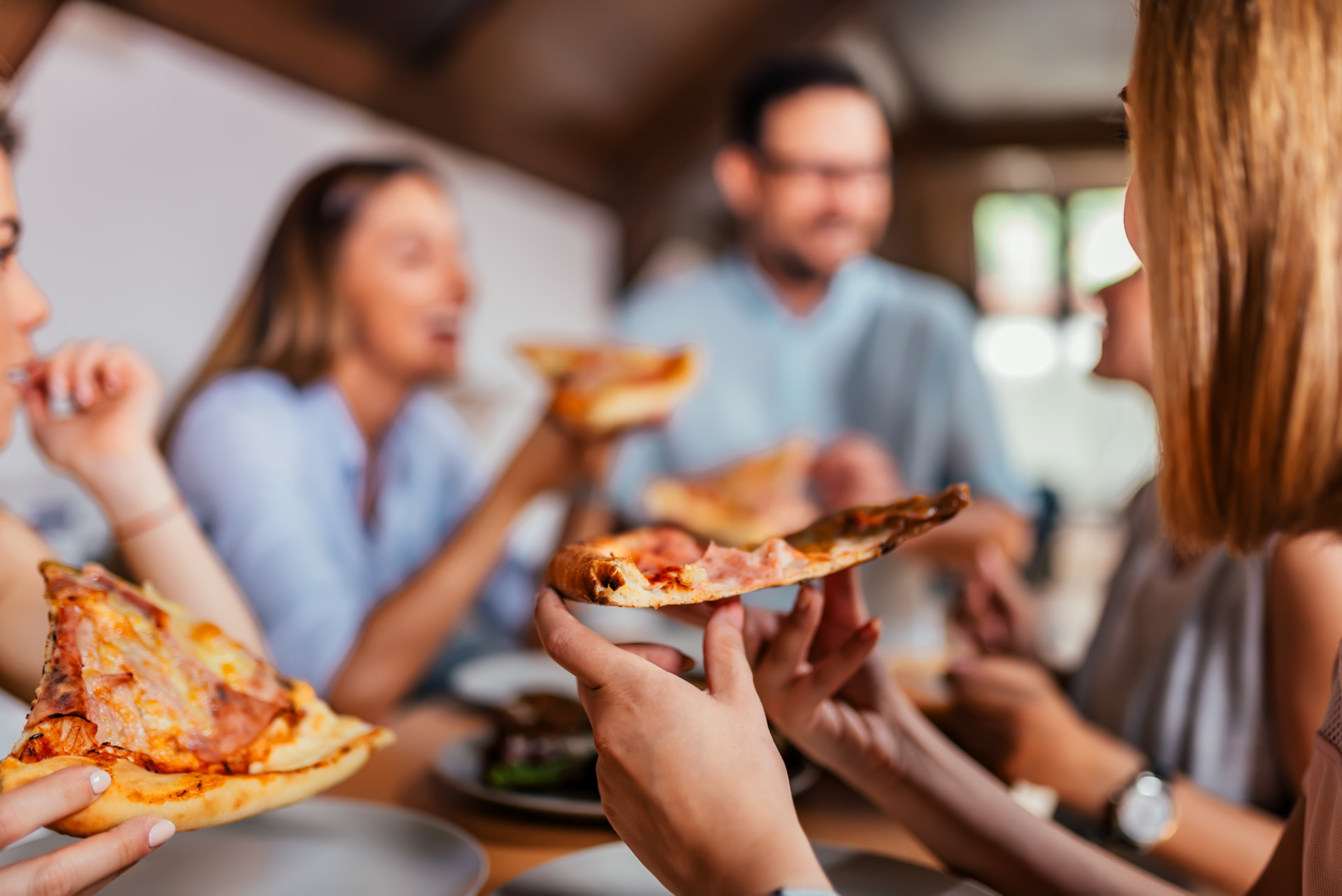 Friends sharing a pizza together at a table — a real crowd enjoying Tony's food